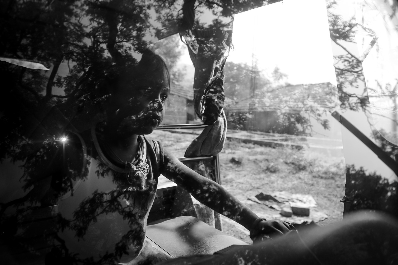 A close-up shot shows a person's hand applying a dark film to the window of a car, with the film partially covering the glass.