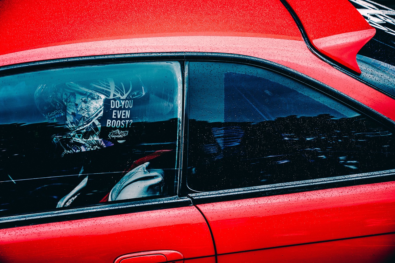 A close-up shot of a car's rear window, partially tinted, with a child's car seat visible inside.