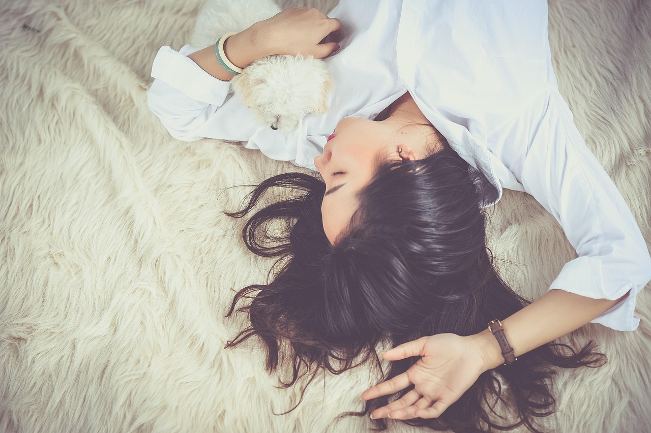 A person is using a handheld vacuum cleaner to remove pet hair from a light-colored carpet.